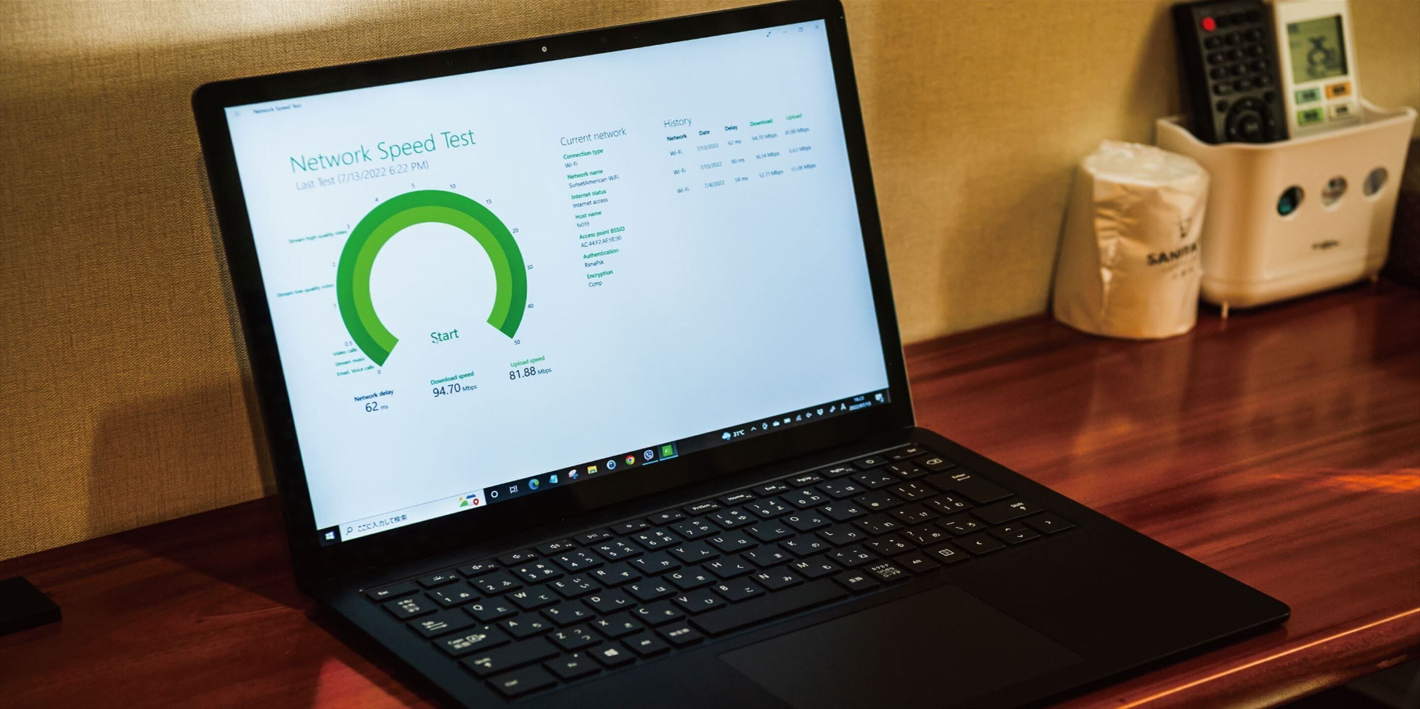Een laptop met een snelheidstest voor internet op een houten tafel.