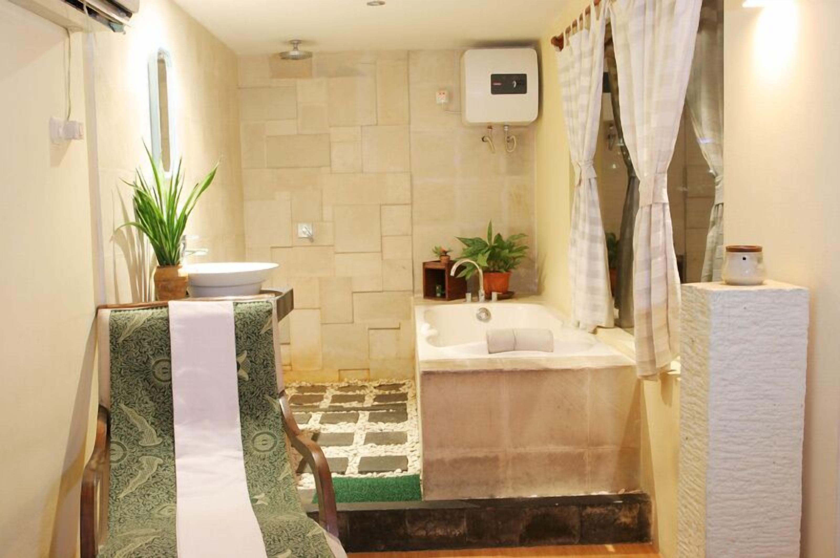 A bathroom with a bathtub, a sink, and a shower area. There are plants and a towel rack.