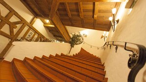 A staircase with wooden steps and white walls, leading to a higher floor. - Hotel Alter Hof (Vaterstetten)