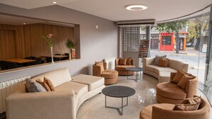 Una sala de estar moderna con un conjunto de sofá, una mesa de centro y una pared espejada.