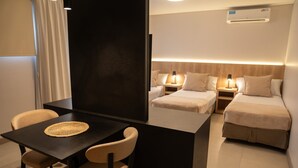 Una habitación de hotel con una cama, mesitas de noche, un escritorio y una silla.