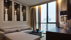 A modern living room with a sofa, a coffee table, and a TV. - Qliq Damansara (Petaling Jaya)