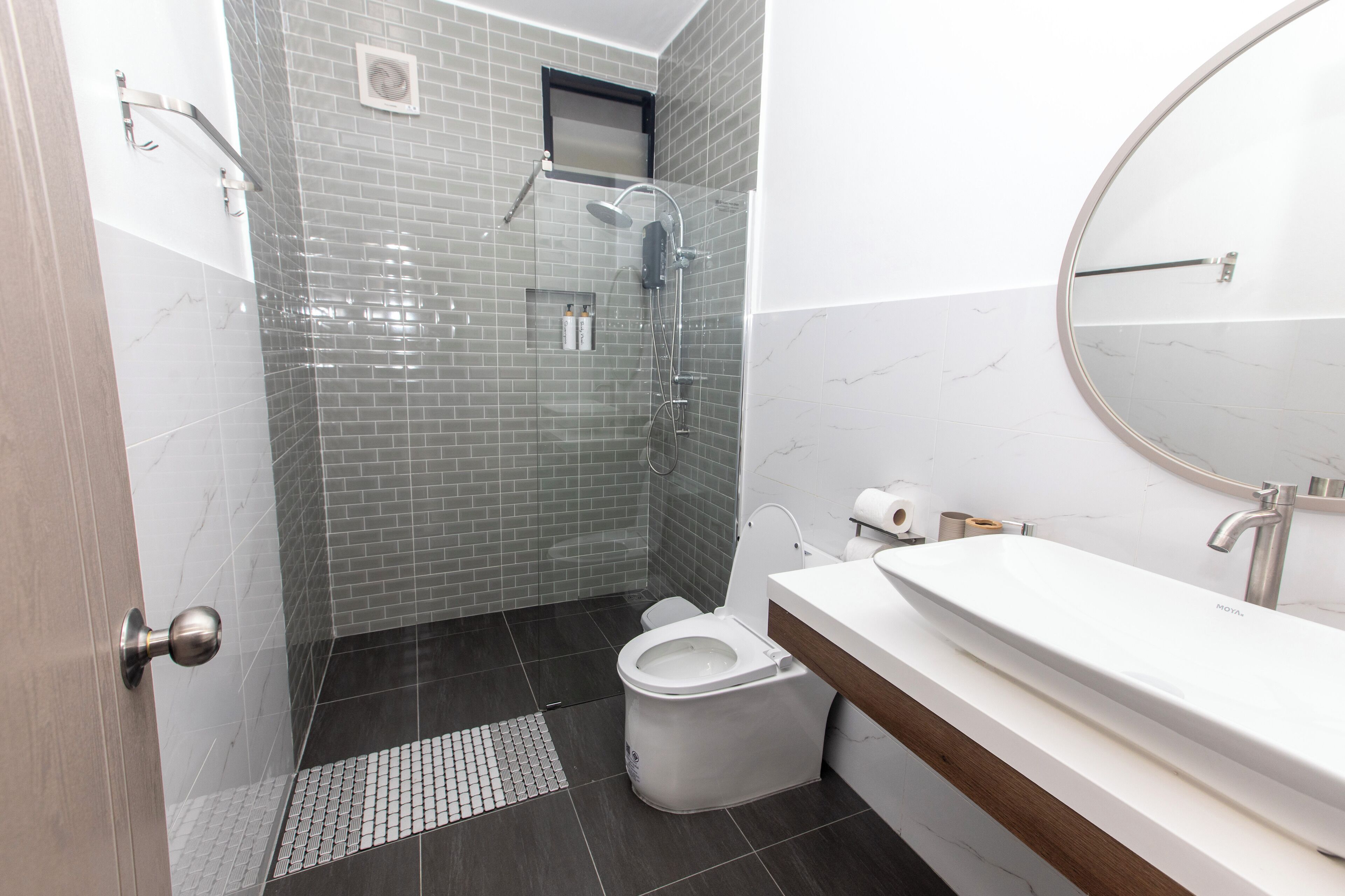 A modern bathroom with a shower, toilet, and sink.