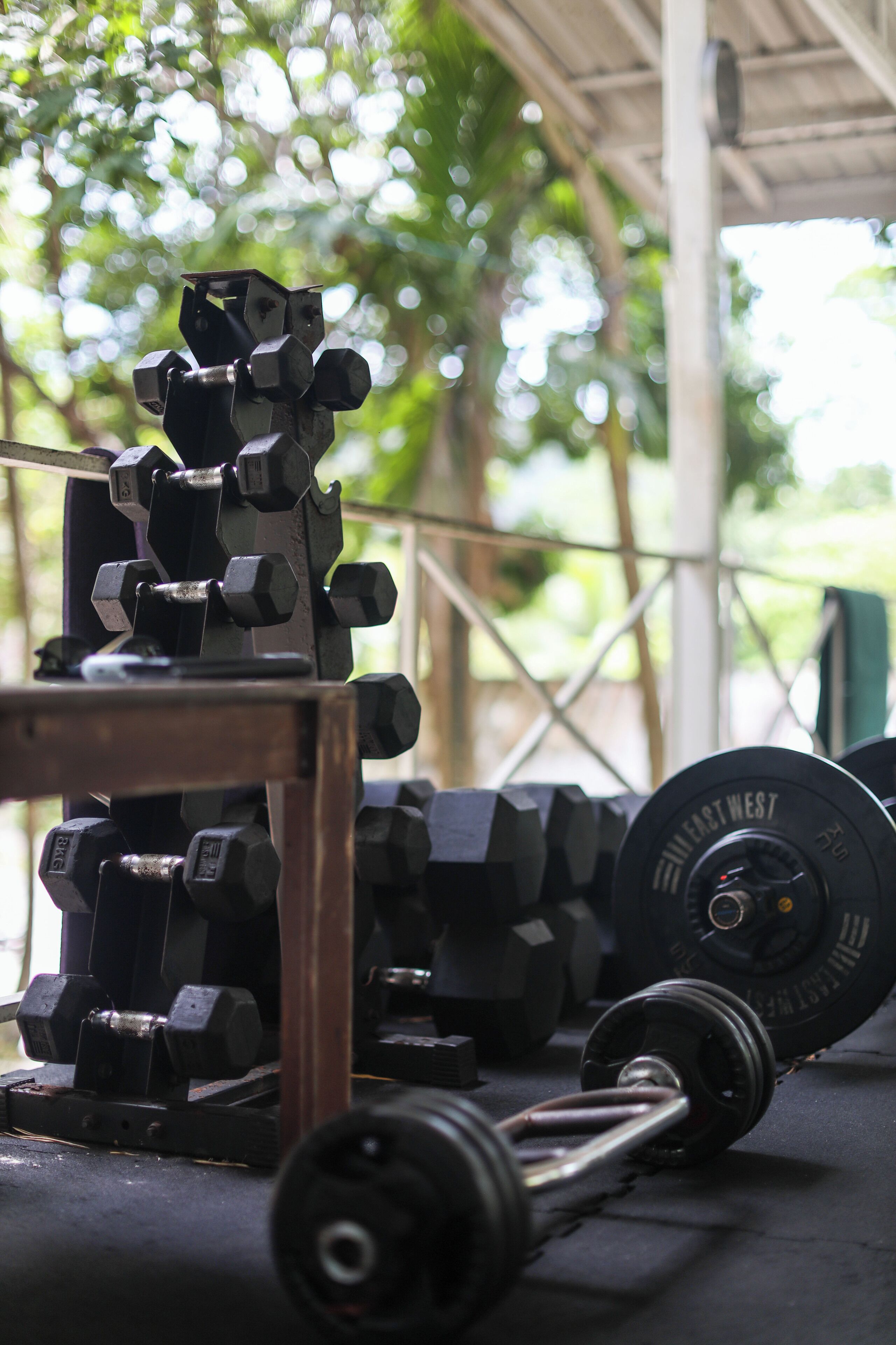 A weightlifting bench with barbells and dumbbells.