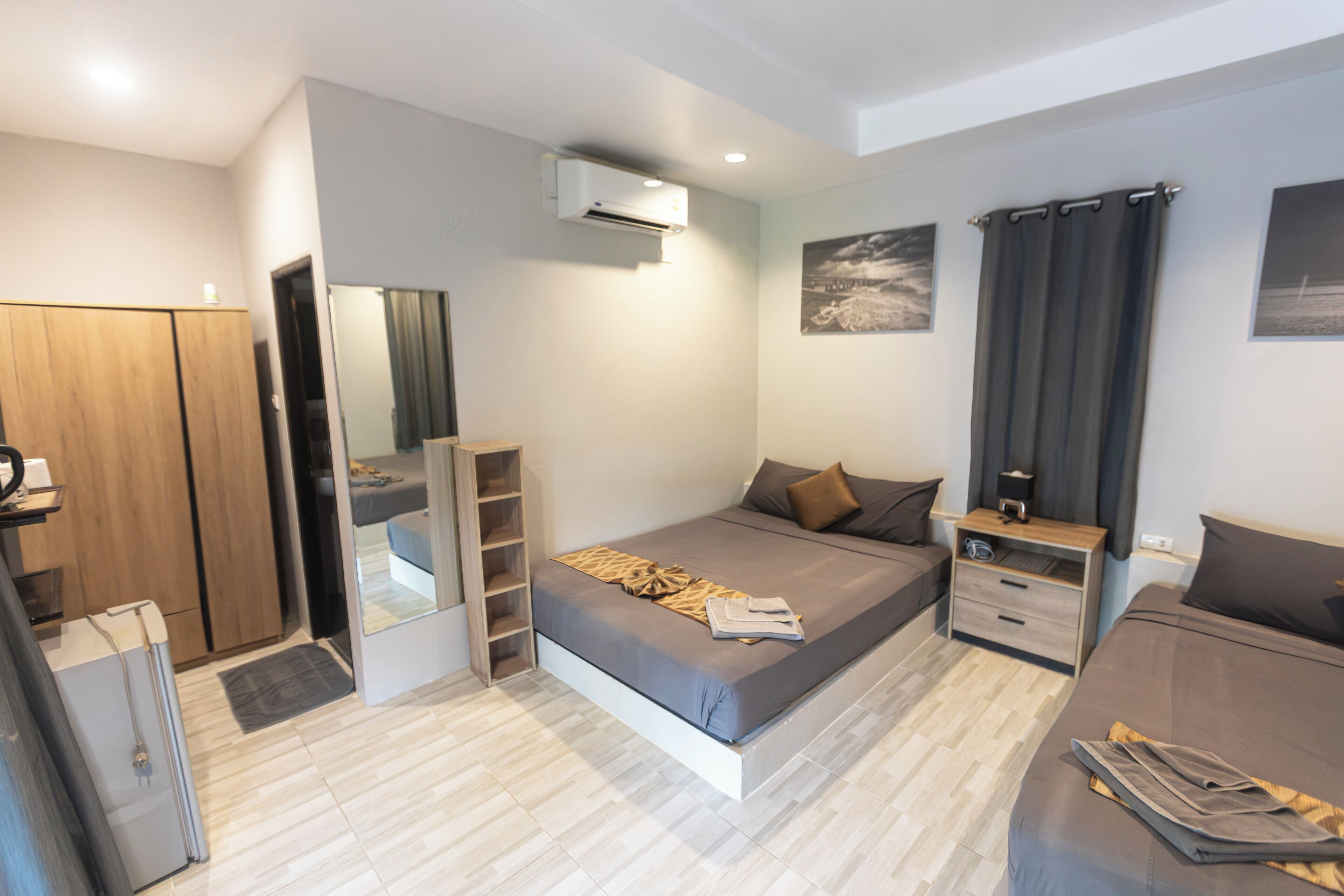 Un dormitorio moderno con cama, mesitas de noche, armario y aire acondicionado.