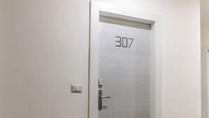 A door with the number 307, a light switch, and a wooden floor.