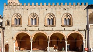 A historic building with a series of arches and a crenellated tower.