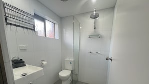 Ein modernes Badezimmer mit Toilette, Waschbecken und Dusche.