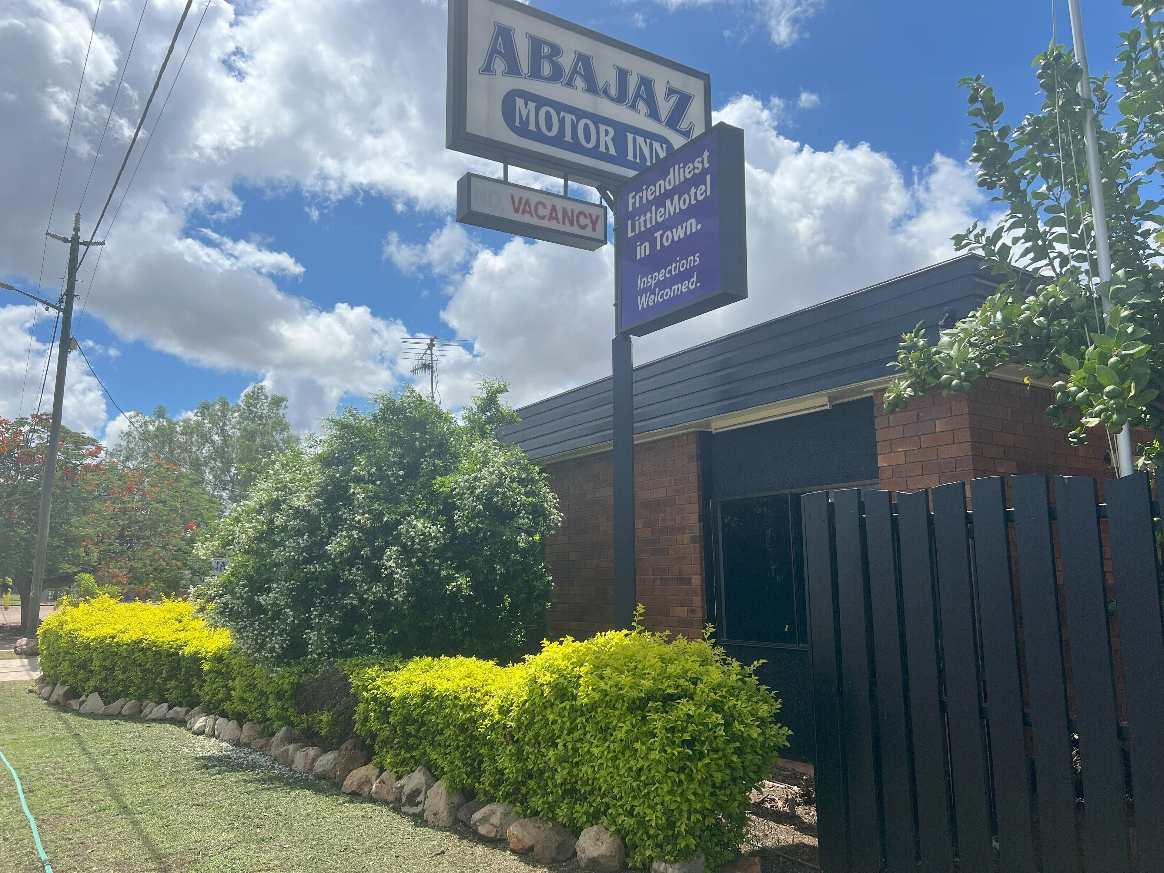 A motel sign with 'ABAJAZ MOTOR INN' and 'VACANCY' indicating available rooms.