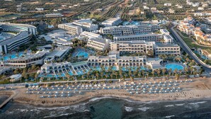 Eine Vogelperspektive zeigt ein Resort mit mehreren Schwimmbecken, Strandliegen und verschiedenen Hotelgebäuden.