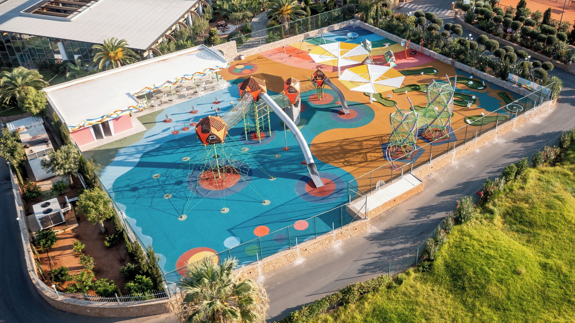 A playground with slides, climbing structures, and a pool area.
