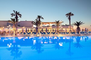 Una piscina al aire libre de temporada, sombrillas, tumbonas