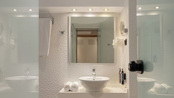Un baño moderno con un espejo grande, dos lavamanos, un inodoro y una zona de ducha.