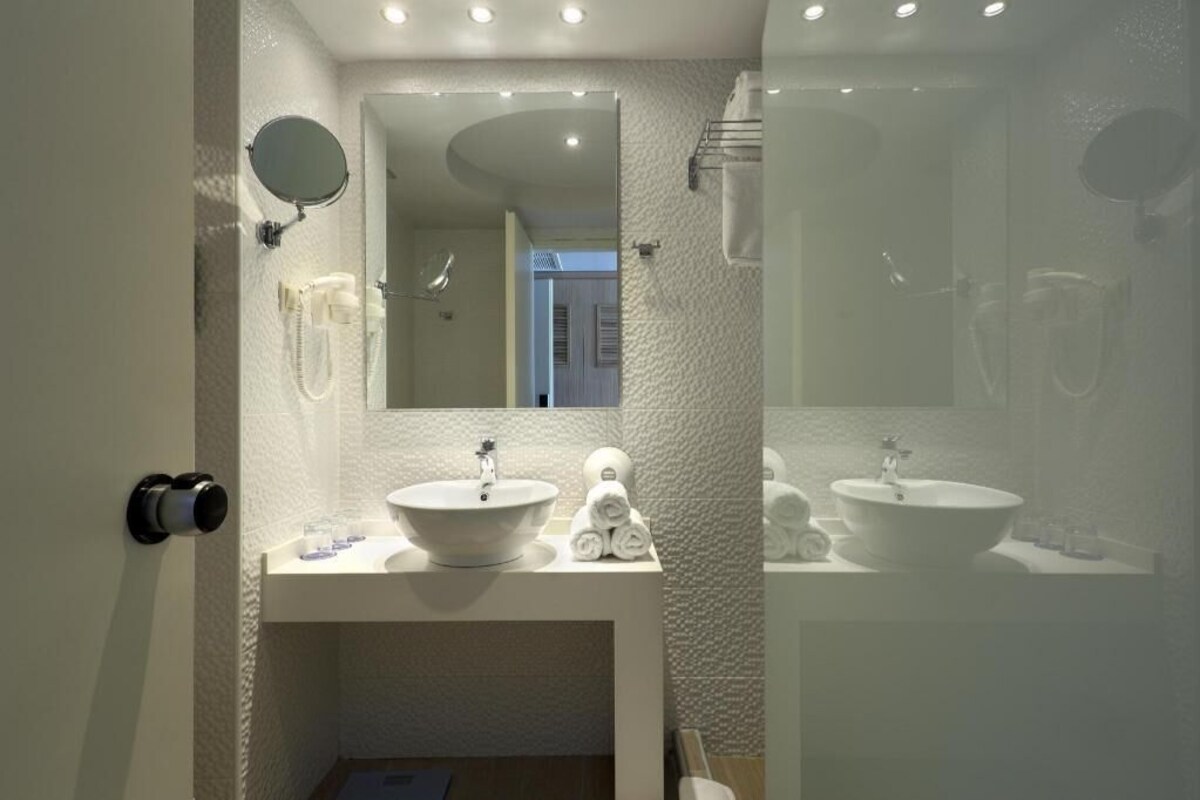 Un baño moderno con dos lavamanos, un espejo y un perchero para toallas.