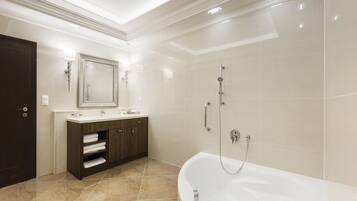 A modern bathroom with a freestanding bathtub, a vanity with a mirror, and a shower area.