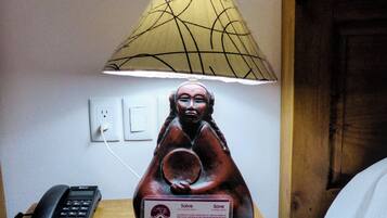 A statue of a figure with a lamp above it, a phone, and a sign with text.