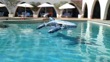 Una piscina al aire libre, sillones reclinables de piscina