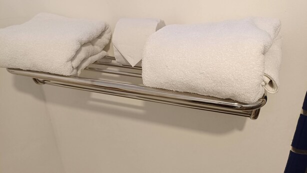 A metal towel rack with three neatly folded white towels. - Hotel Hacienda Bugambilias La Paz & Centro de Convenciones (La Paz)