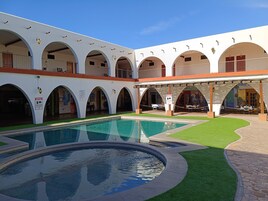 Una piscina al aire libre, sillones reclinables de piscina