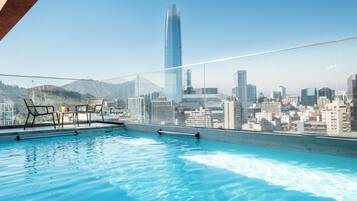 Una piscina al aire libre de temporada, sillones reclinables de piscina