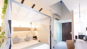 A modern bedroom with a canopy bed, bedside table, and a chair. - Hotel Nuve (Singapore)