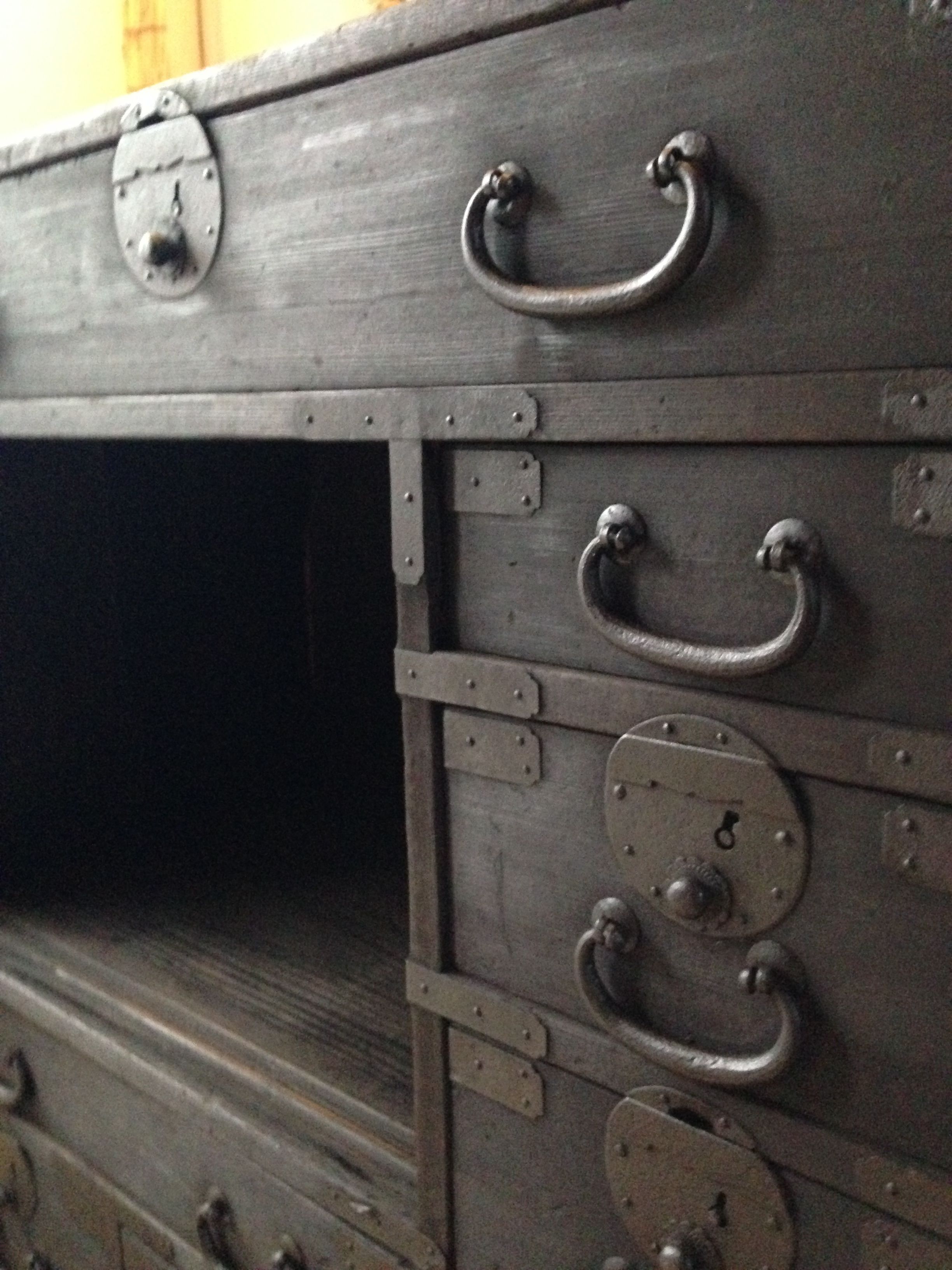A large, metallic, industrial-style chest with multiple handles and latches.