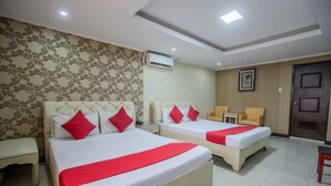 A hotel room with two beds, a small table, a chair, and an air conditioning unit on the wall. - OYO 700 Pj Inn Hotel (Angeles City)