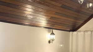A hotel room with a large bed, a nightstand with a lamp, and a wooden ceiling. - Letto Hotel Flores da Cunha (Flores da Cunha)