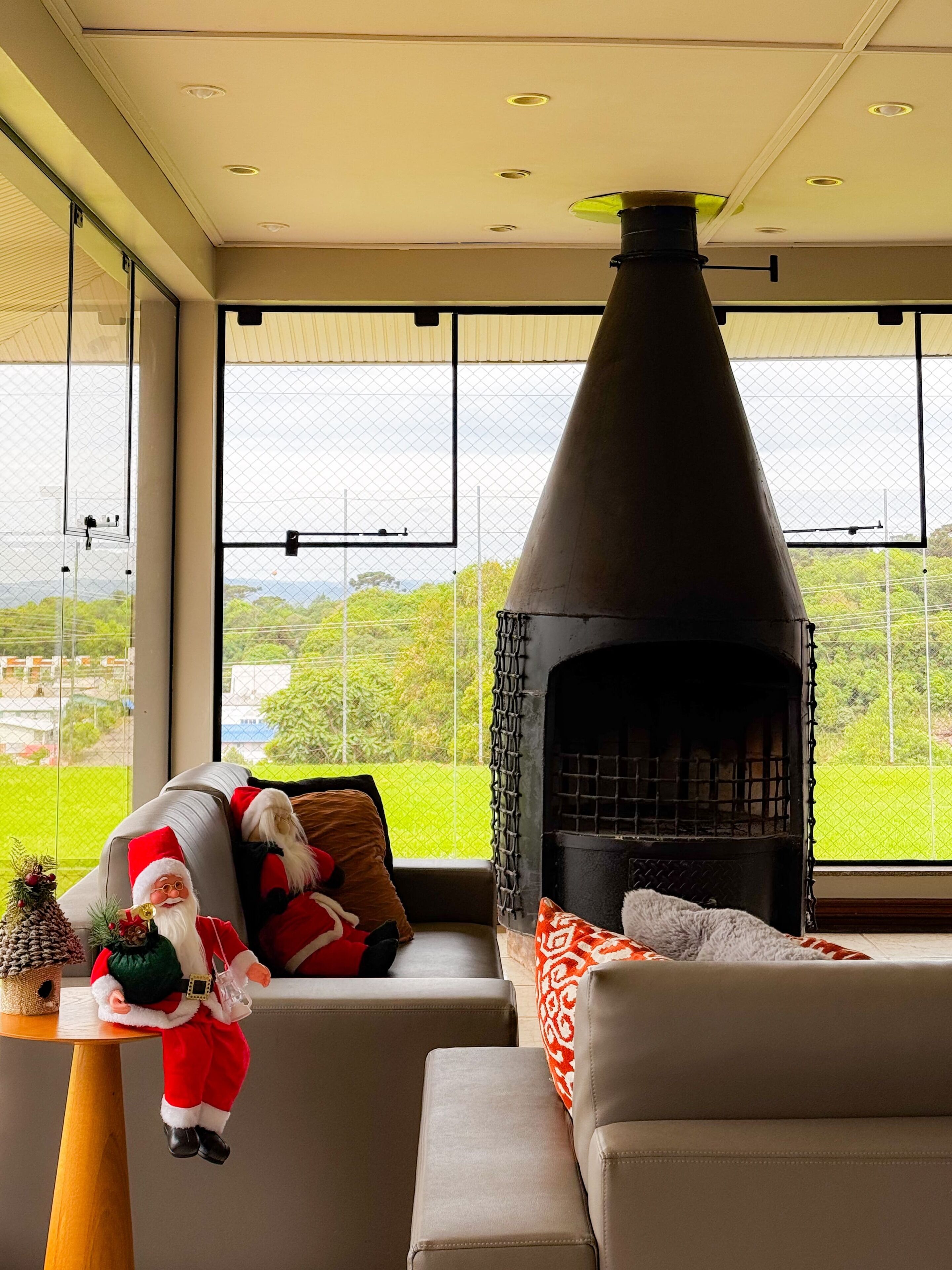 A modern living room with a fireplace, a sofa, and a Christmas decoration.