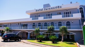 Un hotel llamado "hotel fernandao" con un estilo arquitectónico moderno, que cuenta con balcones y ventanas amplias.