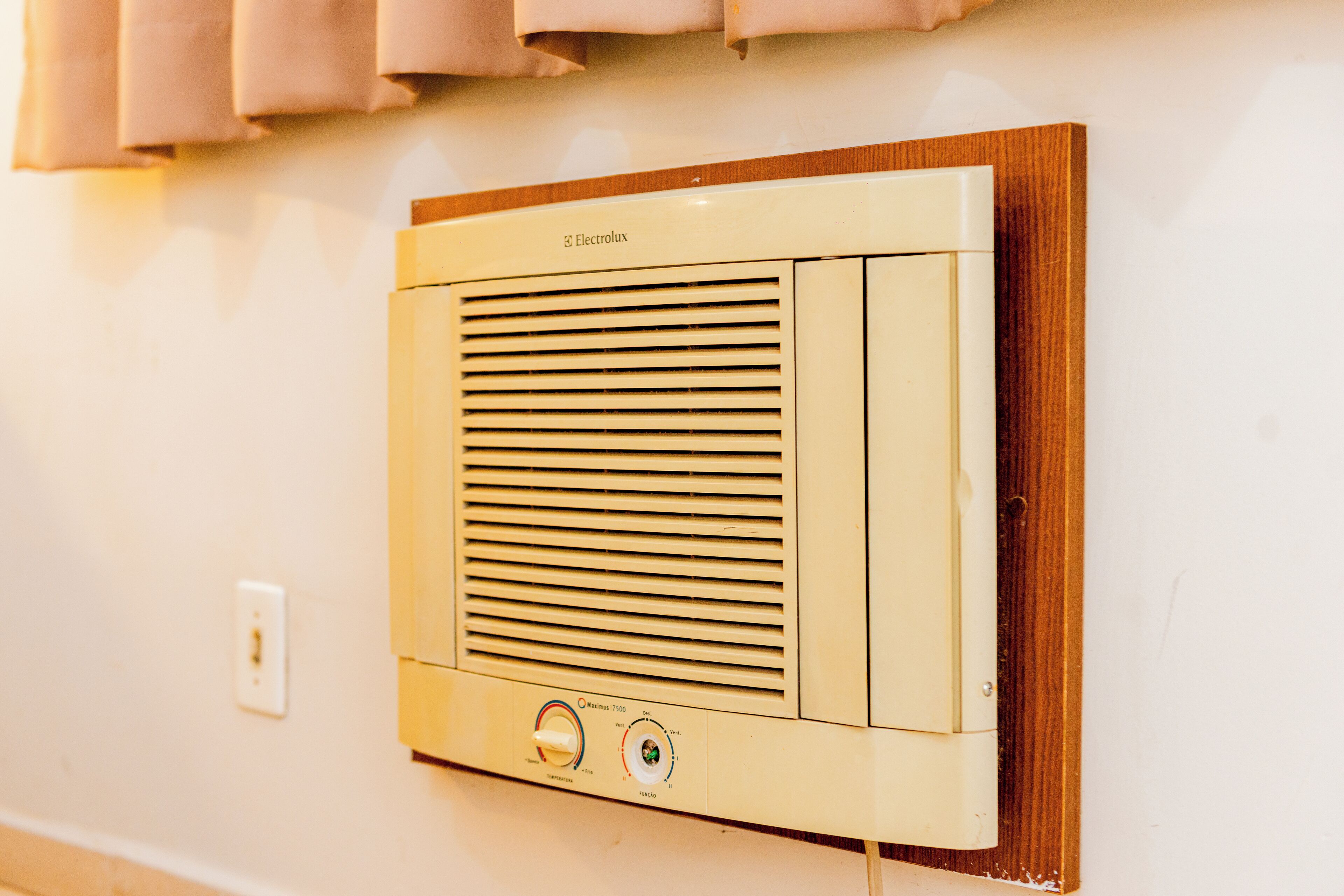 Aire acondicionado Electrolux montado en la pared, con panel de control y marco de madera.