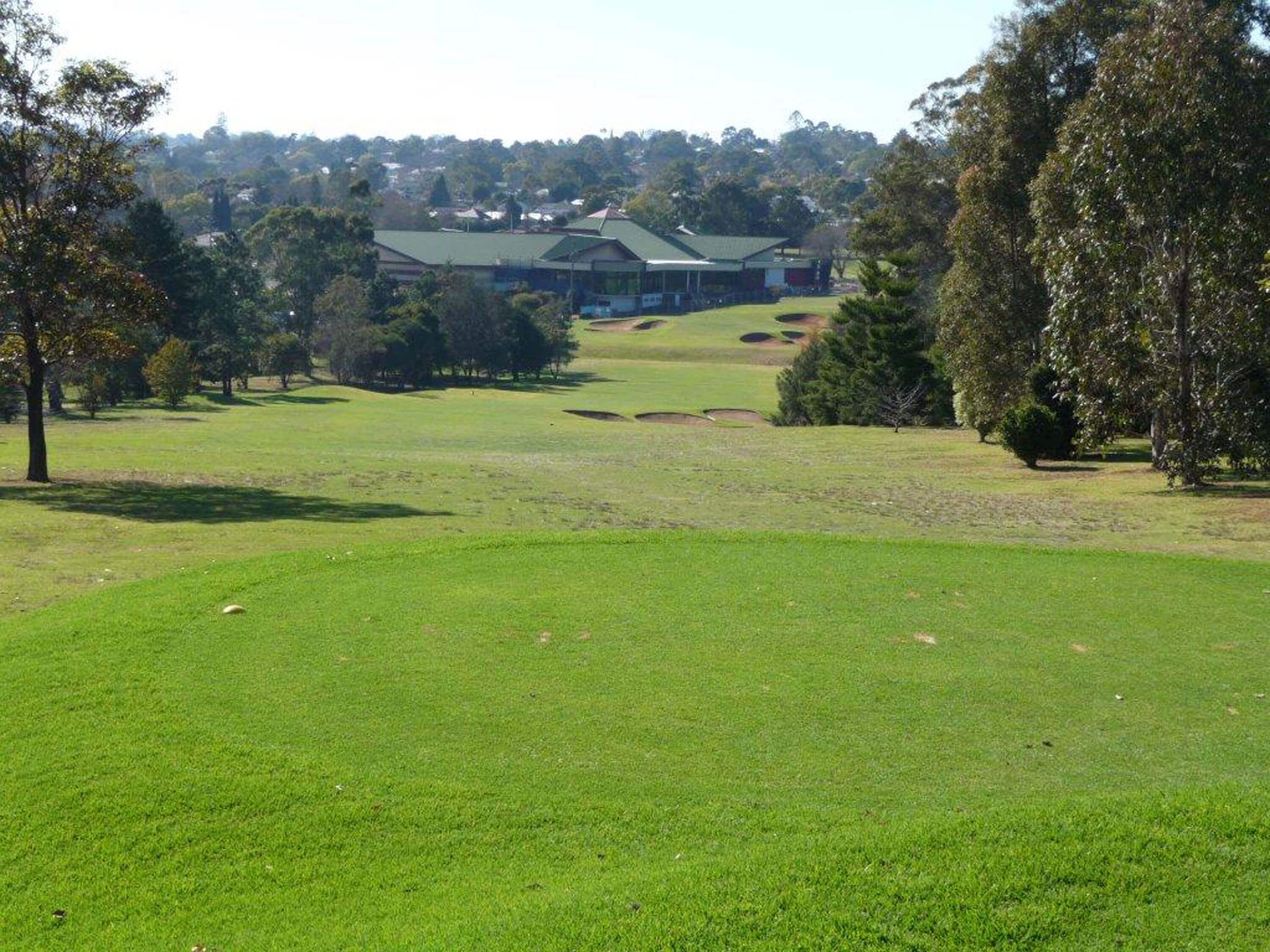 Un campo da golf con un club house sullo sfondo.