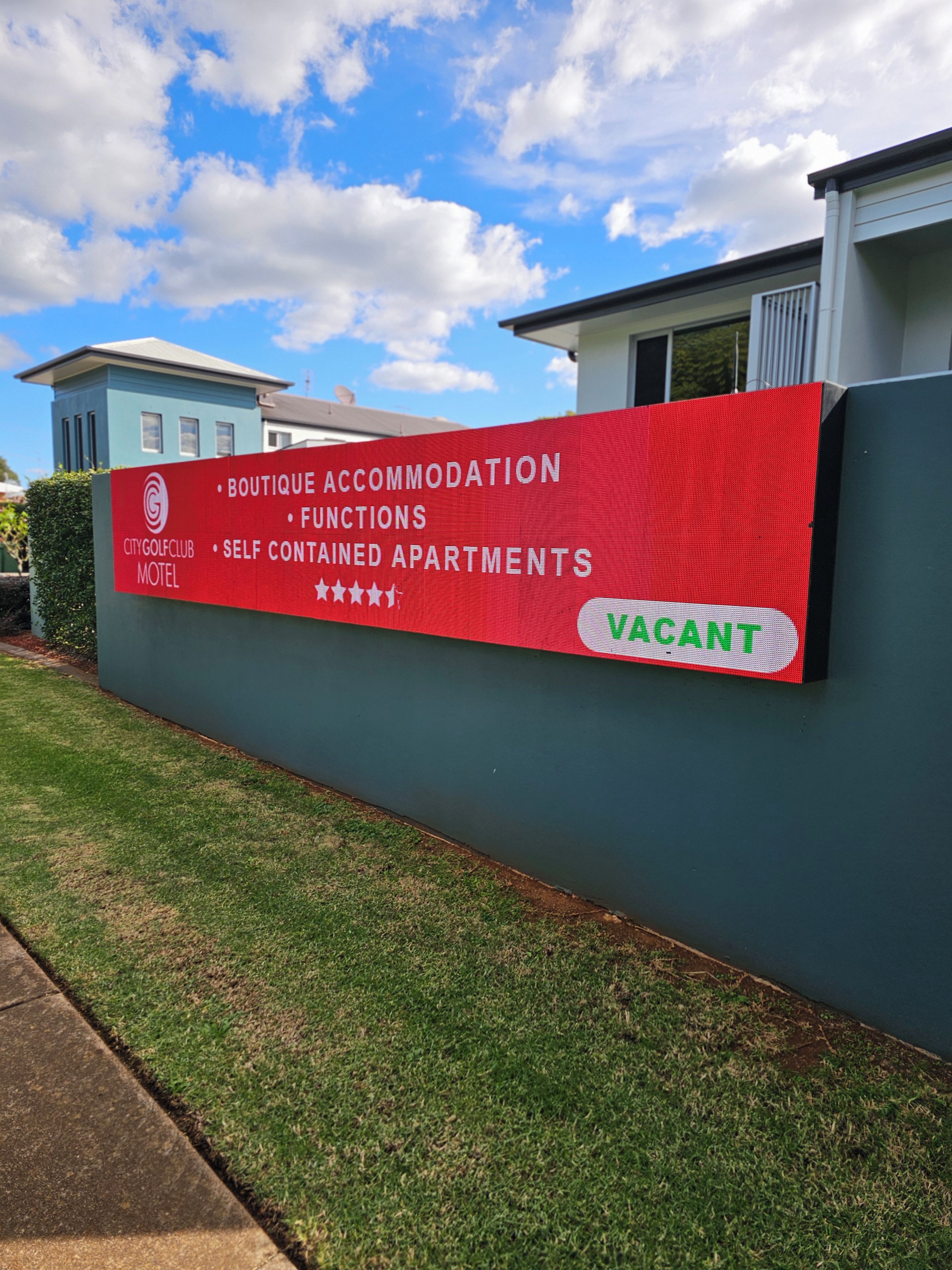 A sign for a City Golf Club Motel advertising boutique accommodation, self-contained apartments, and functions.