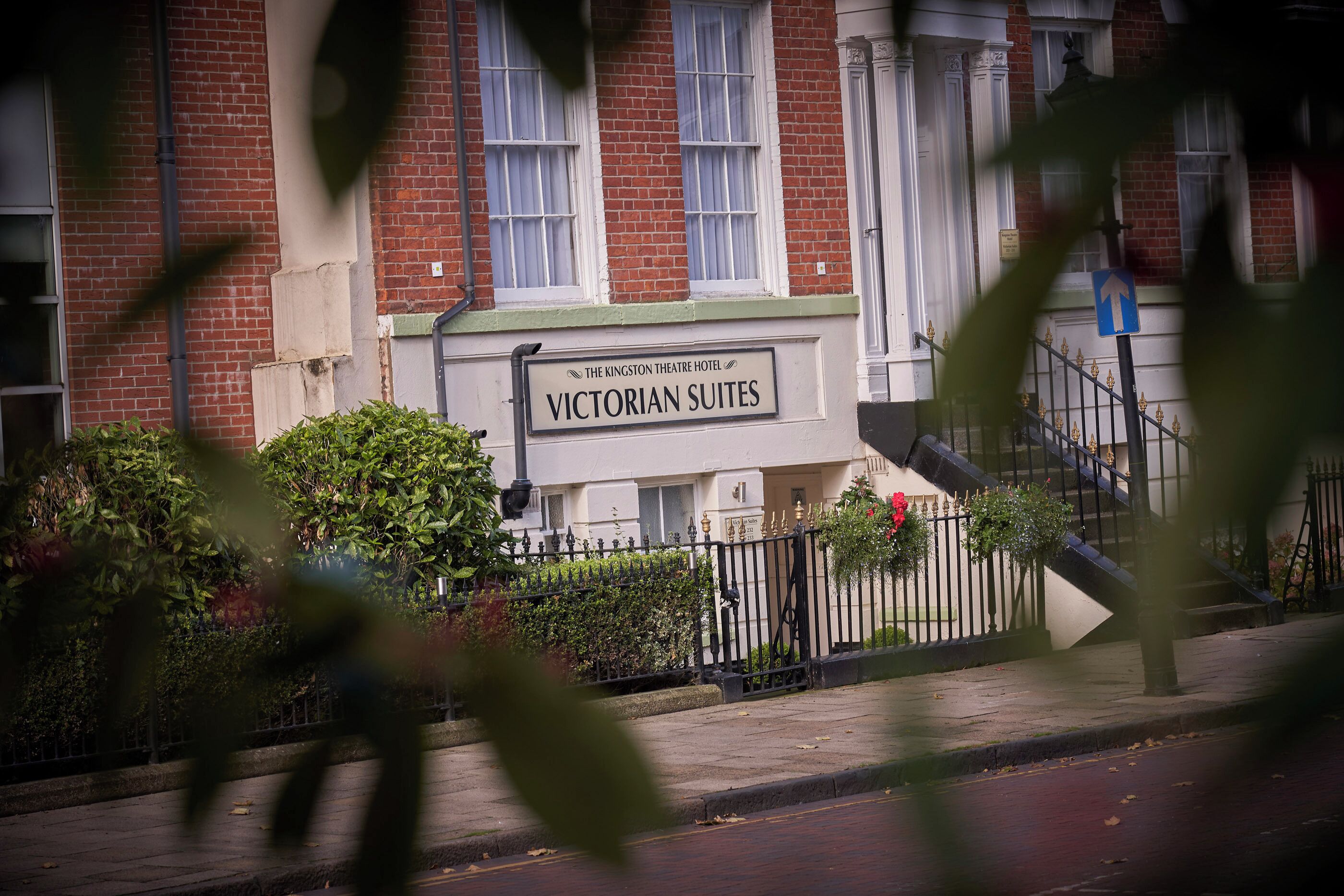 Um hotel em estilo vitoriano com uma placa que diz 'Victorian Suites'.