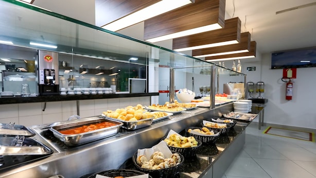 A buffet with various food items and a coffee machine.