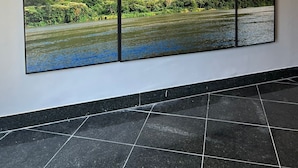 A large wall-mounted artwork depicting a mountainous landscape with a river.