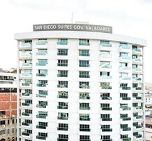 Un edificio de varios pisos con un cartel que dice 'SAN DIEGO SUITES GOV. VALADARES'.
