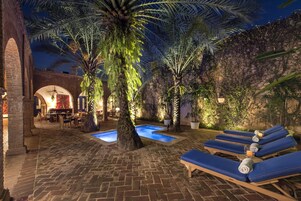 Una piscina al aire libre, sillones reclinables de piscina