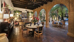 An indoor patio with a round table, chairs, and a ceiling fan.