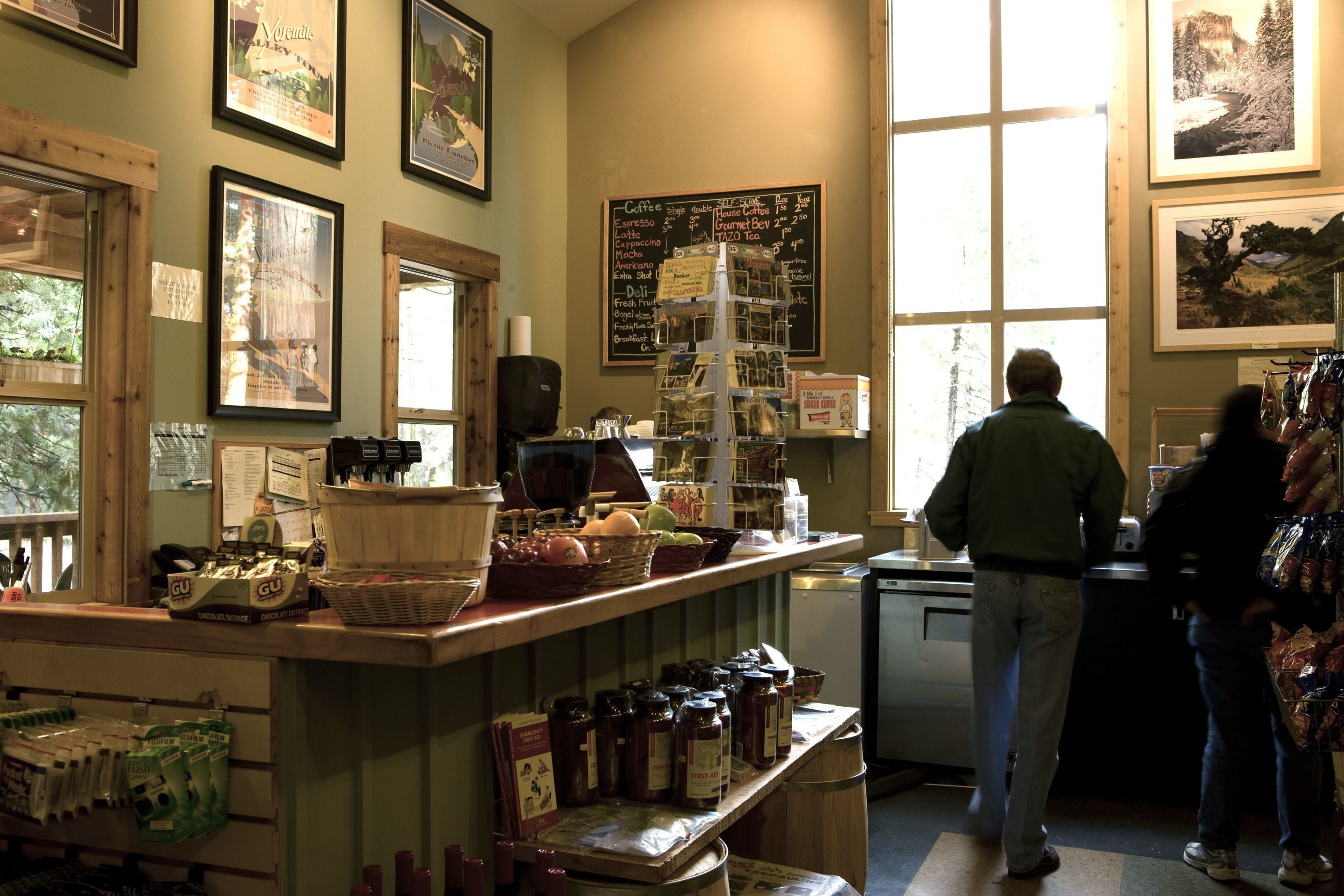 A café with a chalkboard menu, wooden shelves with jars, and a window with natural light.