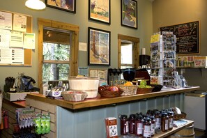 A coffee shop counter with various items like coffee beans, jars, and a menu board.