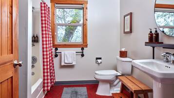 A bathroom with a toilet, sink, and shower.
