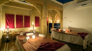 A traditional room with two beds, each with a red towel and a lit candle. - Rang Mahal Jaisalmer (Jaisalmer)
