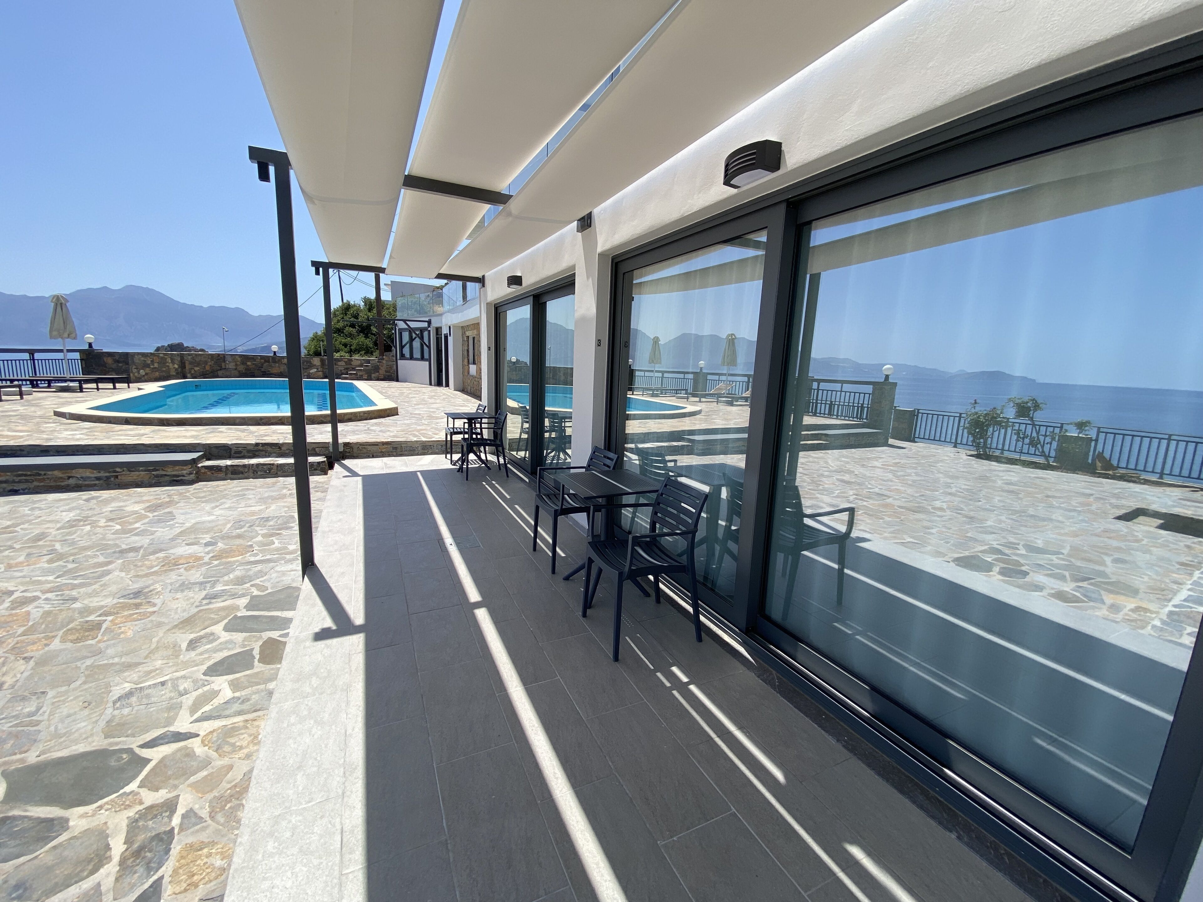Une terrasse sur le toit avec une piscine, des espaces de détente en plein air et une vue sur la mer.