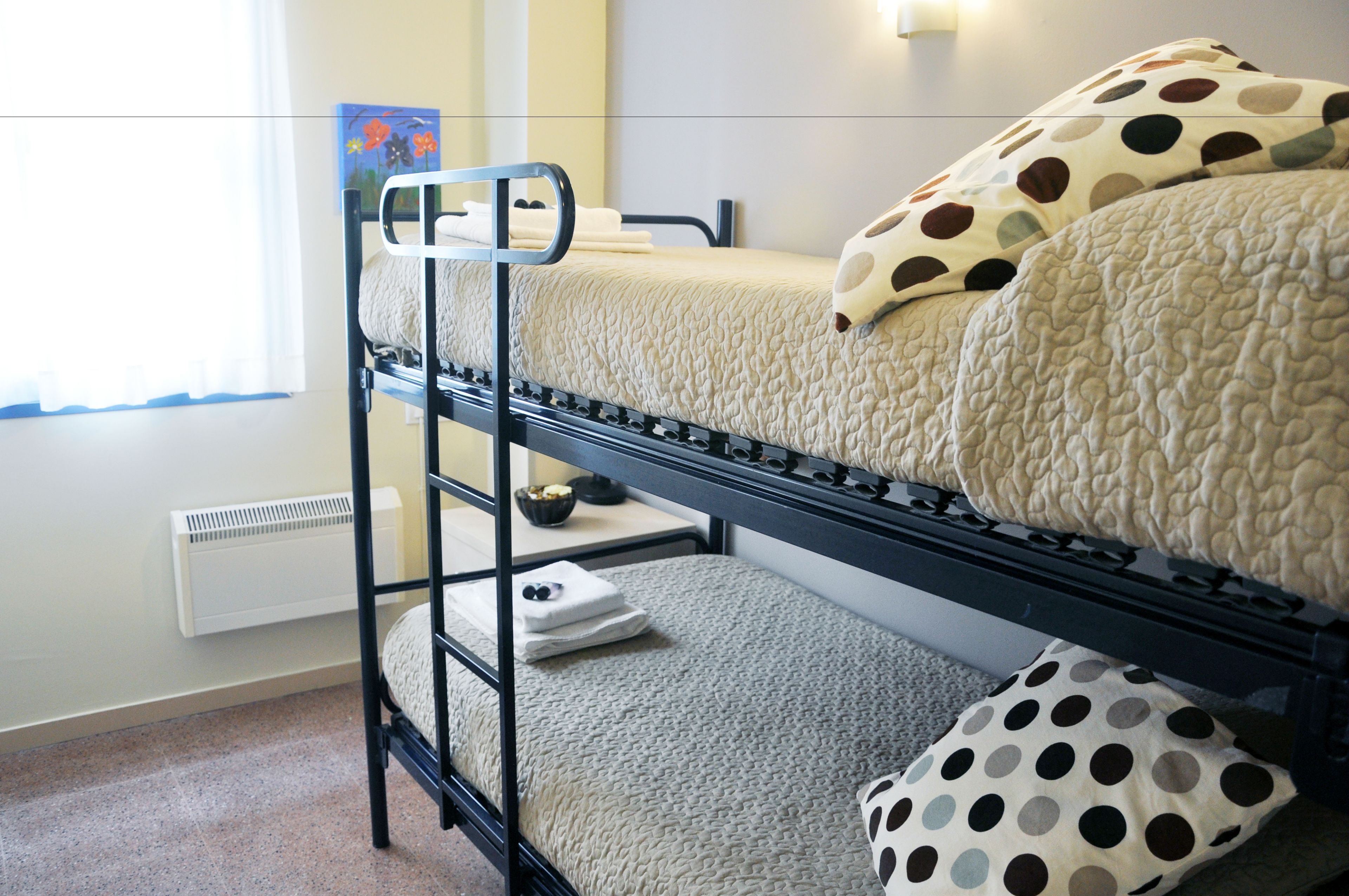 Ein Etagenbett mit einem unterem Bett und einer Matratze im oberen Bett.