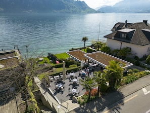 Una propiedad frente al lago con mobiliario exterior, un jardín en la azotea y vistas al lago.