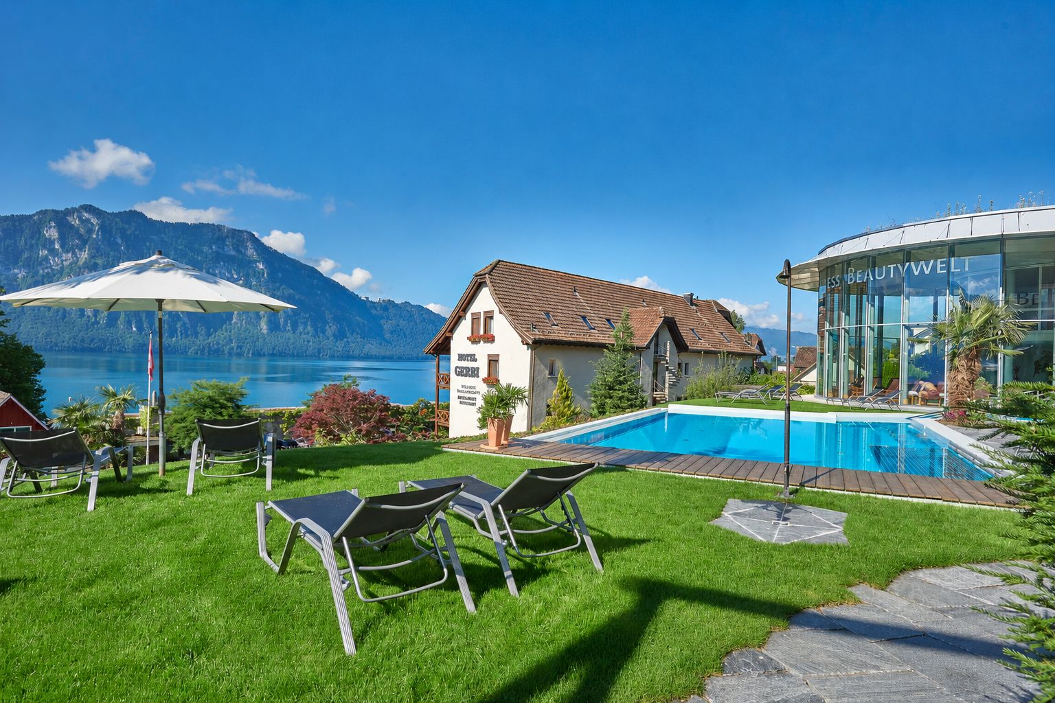 Un hotel con piscina, asientos al aire libre y vistas a la montaña.