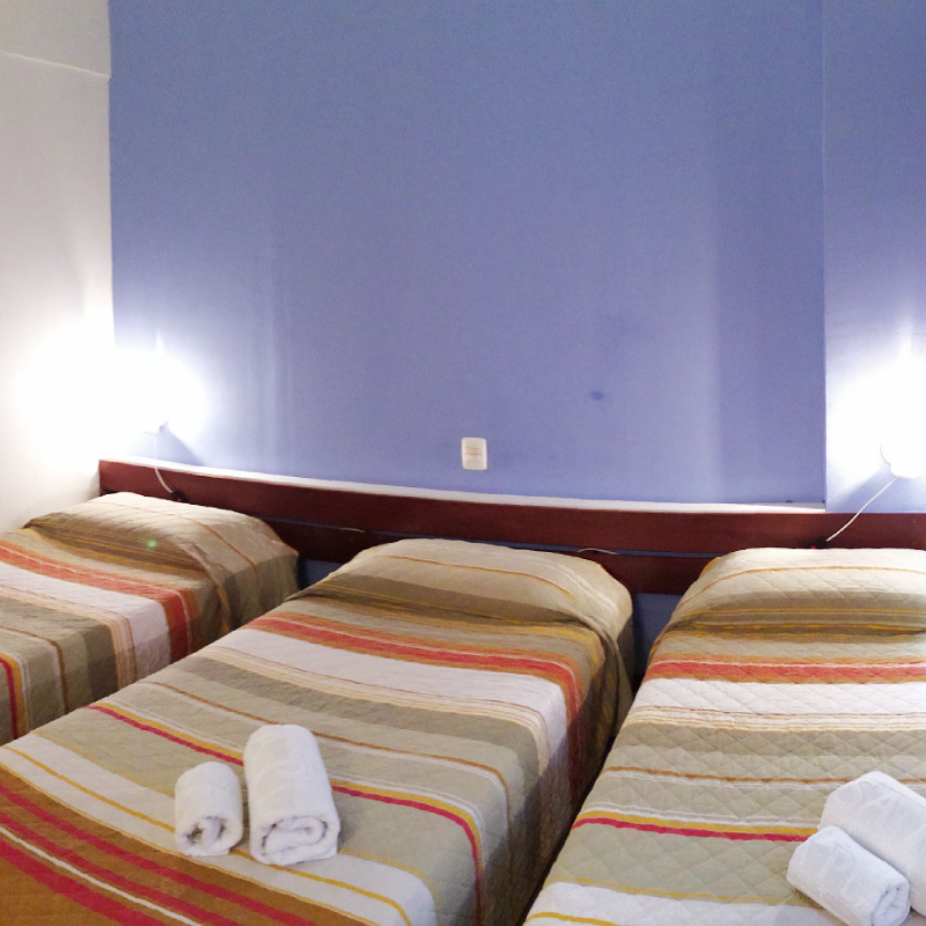 Una habitación de hotel con dos camas, cada una con ropa de cama a rayas y toallas enrolladas.