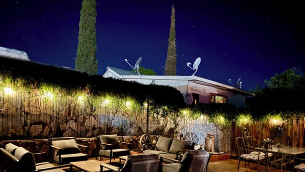 An outdoor patio area with seating and a decorative wall.