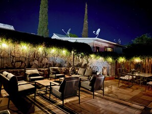 An outdoor patio area with seating and a decorative wall.